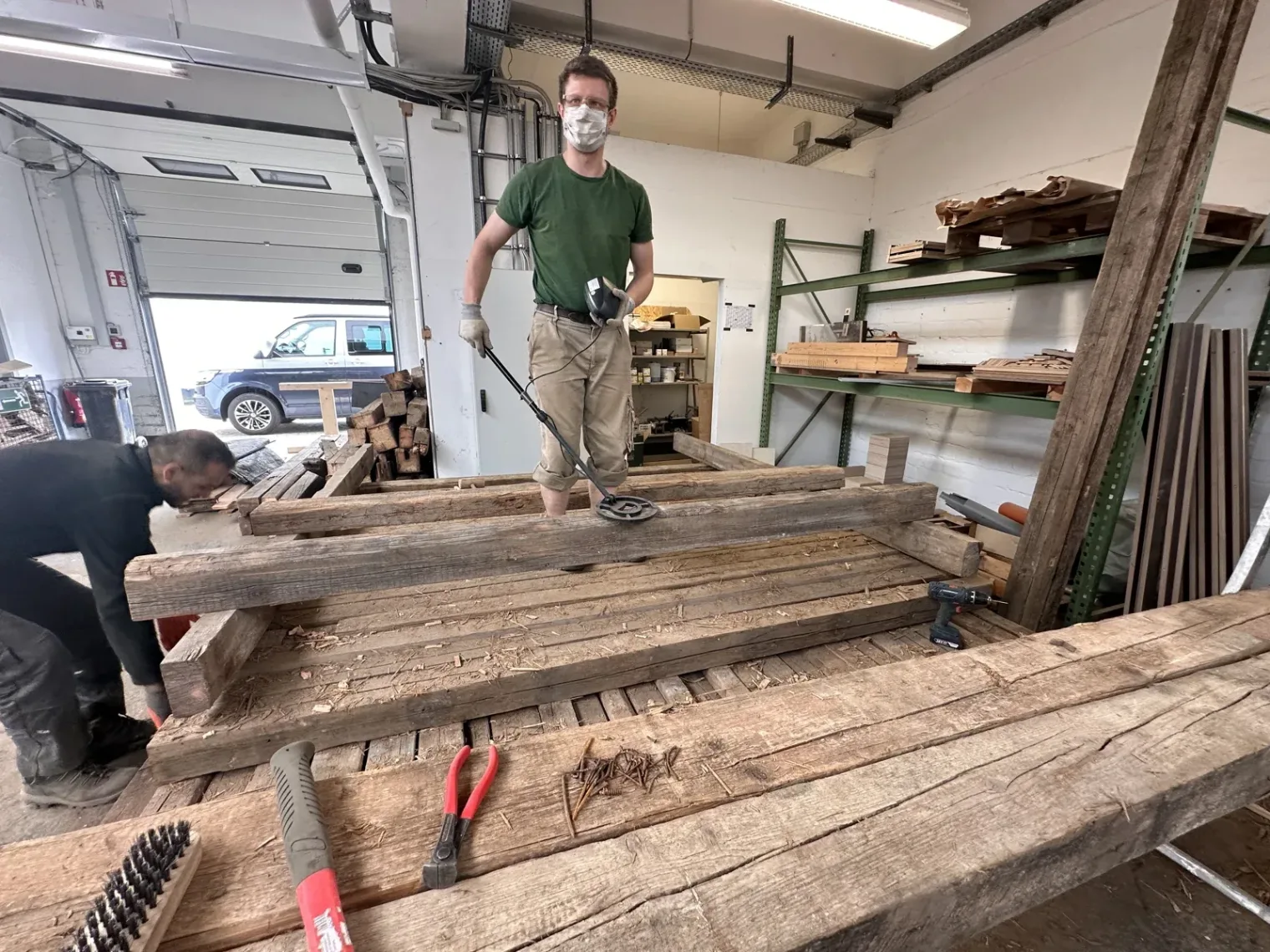 Holzbalken werden in einer Halle mit einem Metalldetektor untersucht. | Seniorenresidenz Fischbeker Höfe