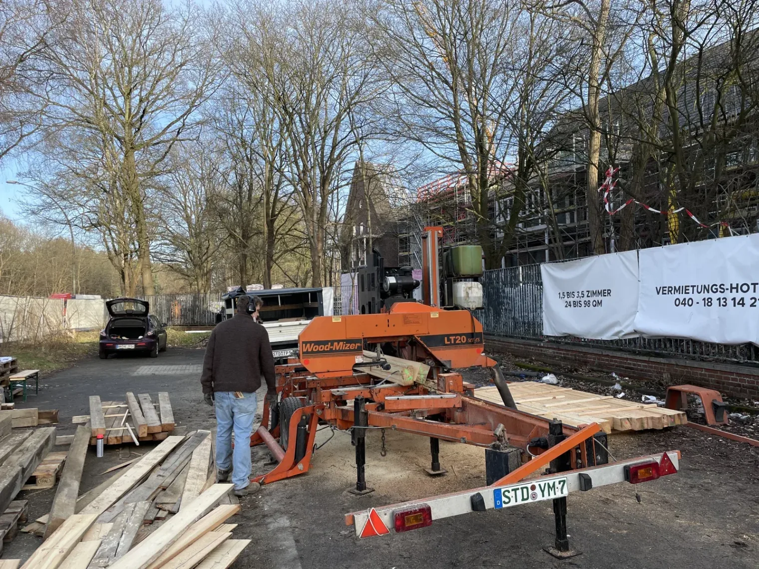 Mobile Säge und geborgene Holzbalken auf der Baustelle. | Seniorenresidenz Fischbeker Höfe